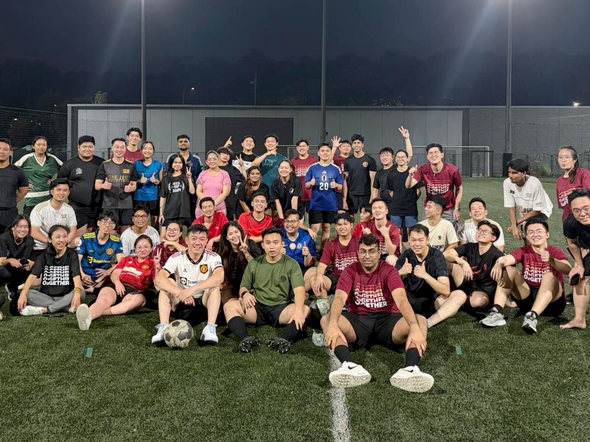 The DC Marketing team gathered on a floodlit pitch after an evening game