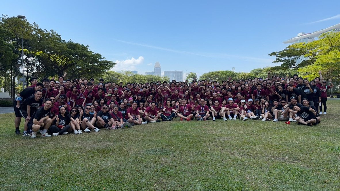 The DC Marketing team gathered on the lawn for a team day, with the Singapore city skyline behind them